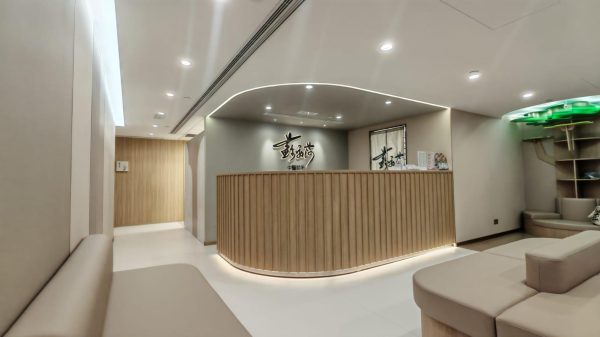 香港商舖裝修工程：現代中醫診所大堂室內設計，弧形木條子接待處及特色陳列櫃訂造實景