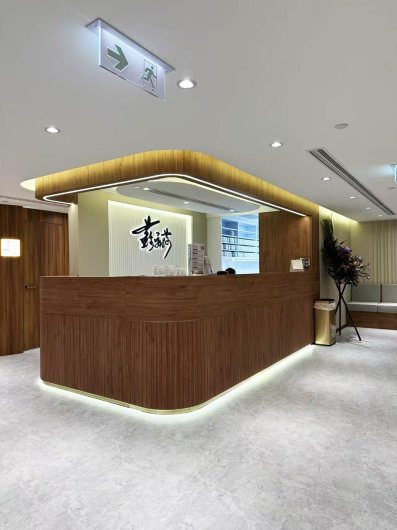 香港商業空間室內設計：新中式風格中醫診所大堂，結合沉穩木質接待櫃枱與雅致品牌背景牆的商舖裝修工程